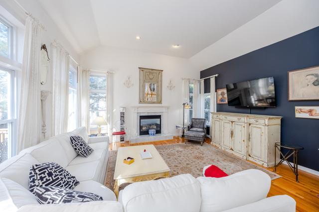 living room with light wood-type flooring and vaulted ceiling