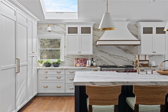 kitchen featuring custom exhaust hood and white cabinetry