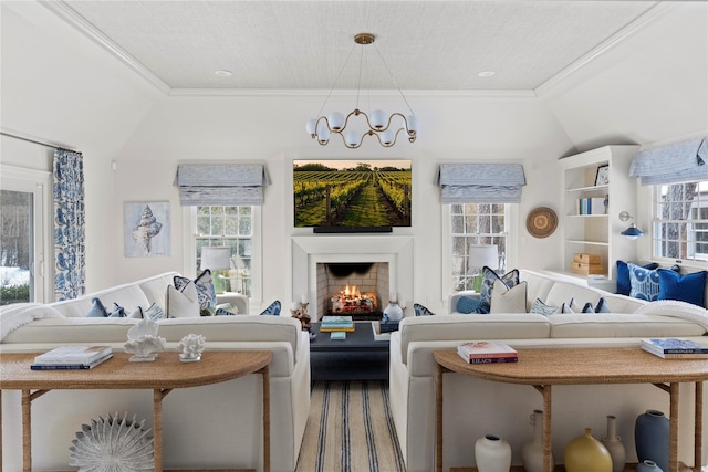 living room featuring crown molding, an inviting chandelier, and vaulted ceiling