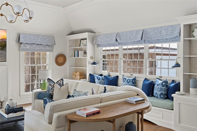 living room featuring a notable chandelier, dark wood-type flooring, plenty of natural light, and ornamental molding