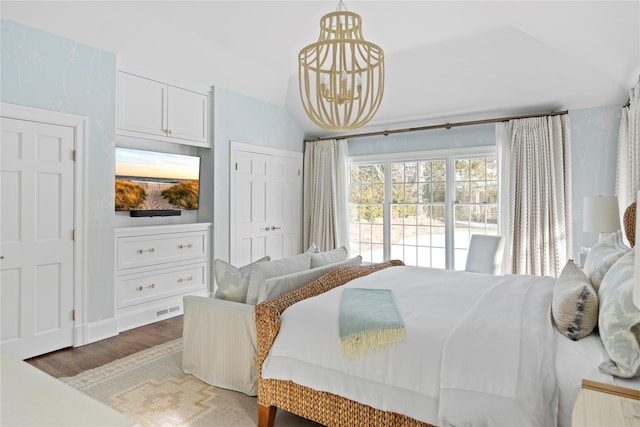 bedroom featuring lofted ceiling, a notable chandelier, hardwood / wood-style flooring, and access to outside