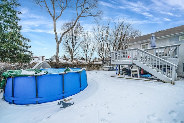 yard covered in snow with a pool side deck