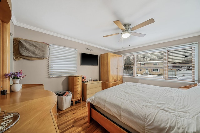 bedroom with hardwood / wood-style flooring, ceiling fan, and ornamental molding