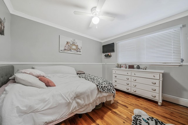 bedroom with ornamental molding, light wood-type flooring, ceiling fan, and baseboard heating