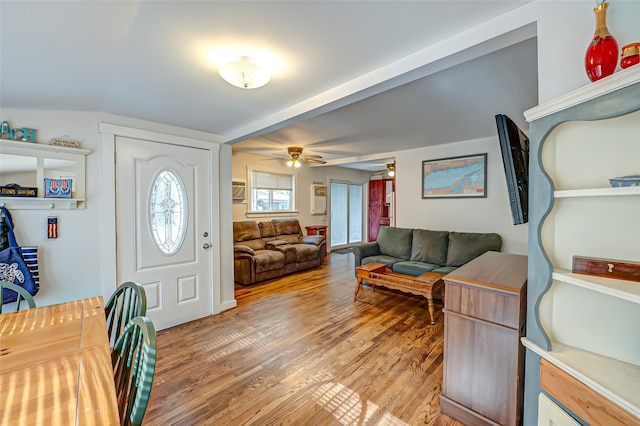 foyer with wood-type flooring and vaulted ceiling