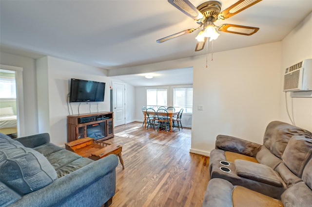 living room with a wall mounted air conditioner, plenty of natural light, and wood-type flooring