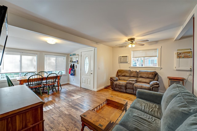 living room with hardwood / wood-style floors, a wall mounted air conditioner, a healthy amount of sunlight, and ceiling fan