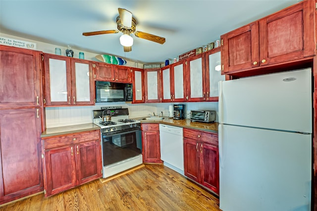 kitchen featuring ceiling fan, light wood-type flooring, sink, and white appliances