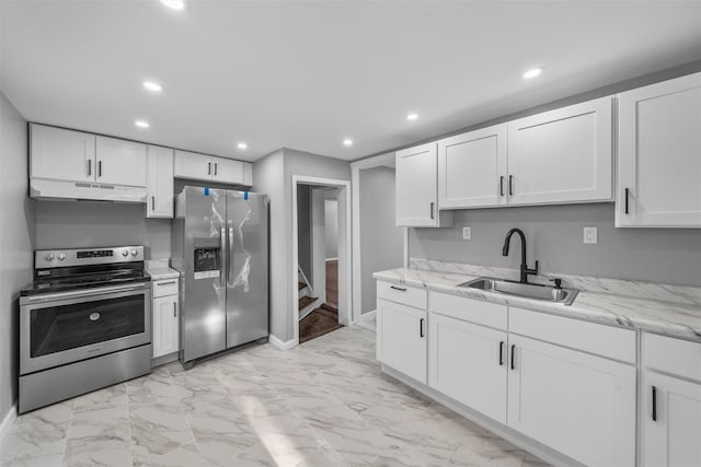 kitchen with sink, stainless steel appliances, white cabinets, and light stone countertops