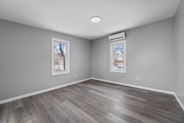 spare room featuring dark hardwood / wood-style floors and a wall mounted air conditioner