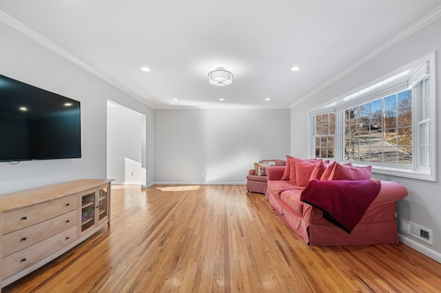 living room featuring crown molding and light hardwood / wood-style flooring