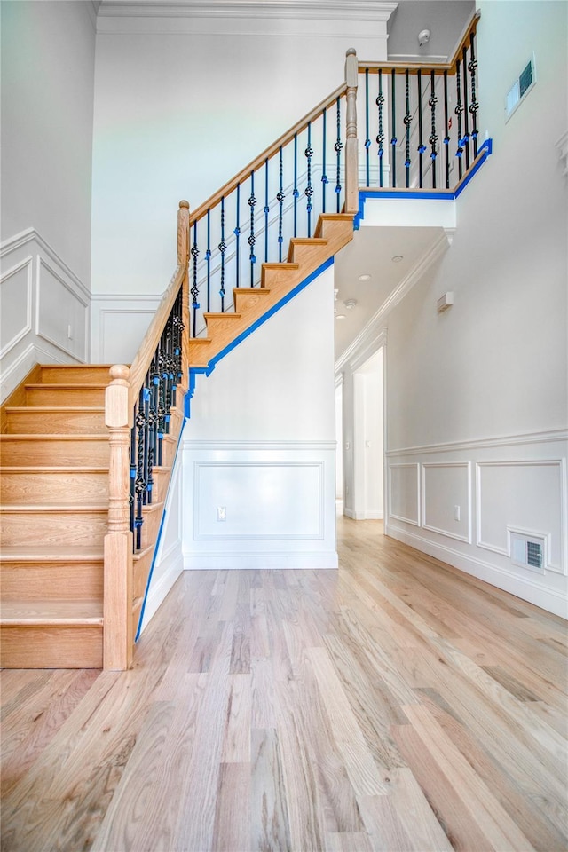 stairway featuring hardwood / wood-style flooring and ornamental molding