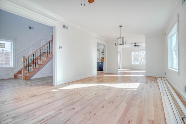 interior space featuring crown molding, ceiling fan with notable chandelier, and light hardwood / wood-style flooring