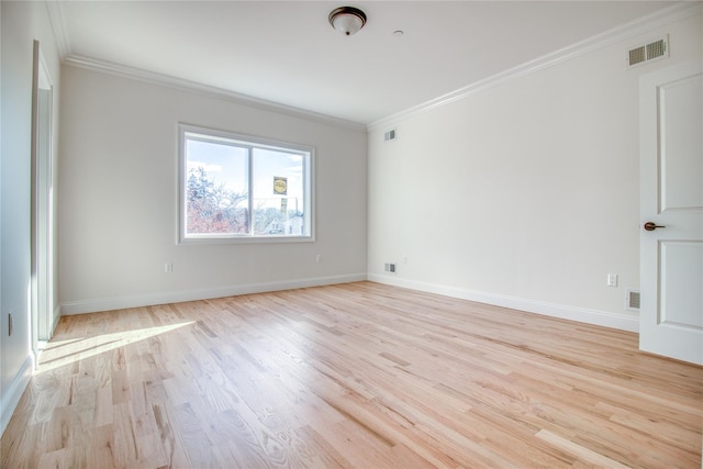 spare room with ornamental molding and light wood-type flooring