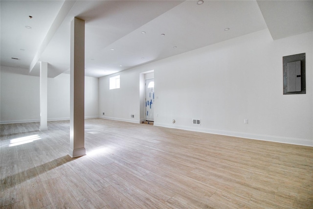 basement with electric panel and light hardwood / wood-style flooring