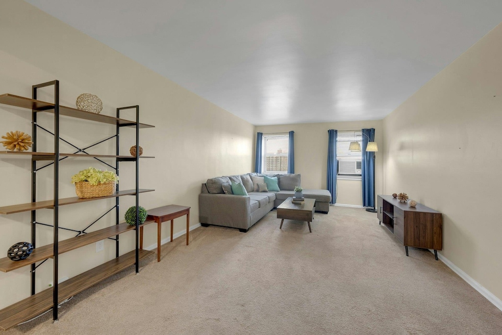 living room with light colored carpet and cooling unit