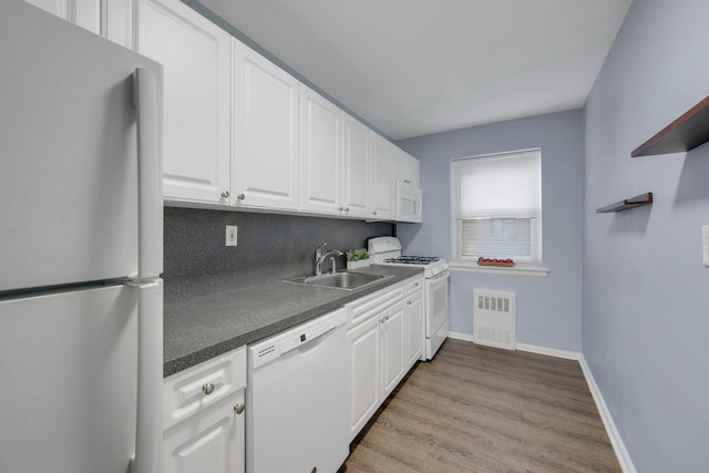 kitchen featuring sink, white appliances, light hardwood / wood-style flooring, tasteful backsplash, and white cabinets