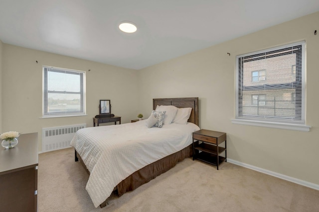 bedroom with radiator and light carpet