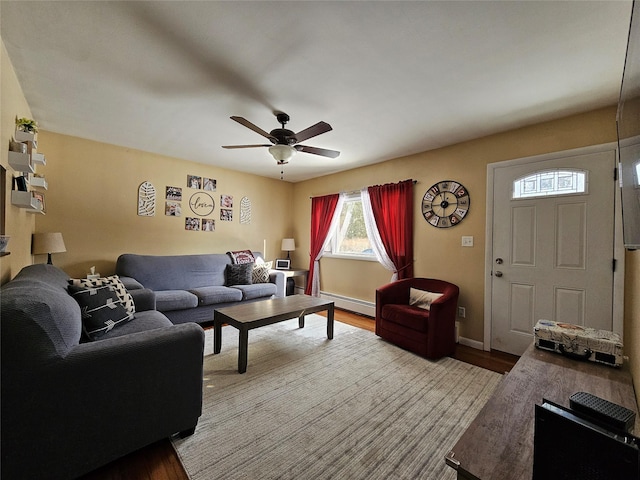 living room featuring baseboard heating, ceiling fan, and wood-type flooring