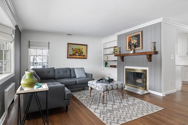 living room with ornamental molding, dark hardwood / wood-style floors, and built in shelves