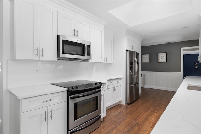 kitchen featuring light stone counters, dark hardwood / wood-style floors, white cabinets, and appliances with stainless steel finishes