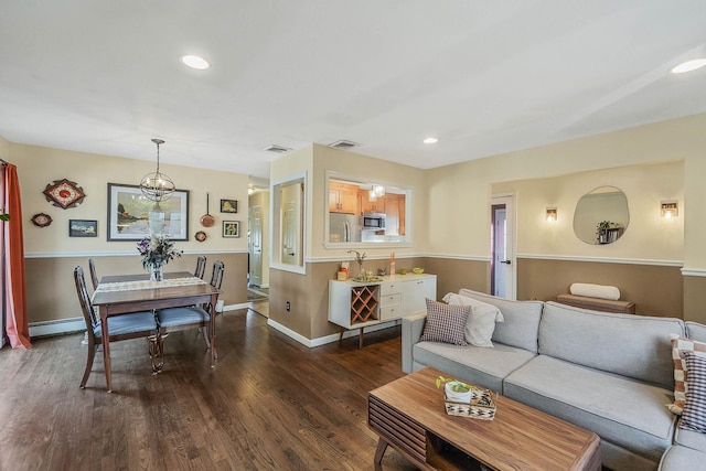 living room with dark hardwood / wood-style flooring and a baseboard heating unit