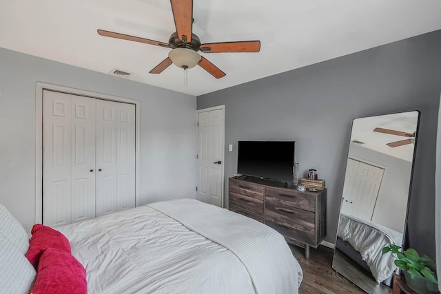 bedroom with a closet, dark hardwood / wood-style floors, and ceiling fan