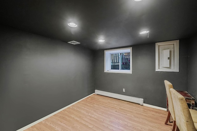 interior space featuring electric panel, baseboard heating, and light hardwood / wood-style floors