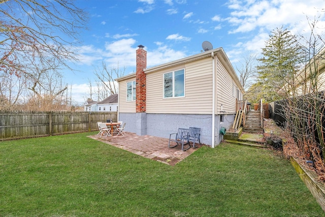 rear view of property featuring a lawn and a patio area