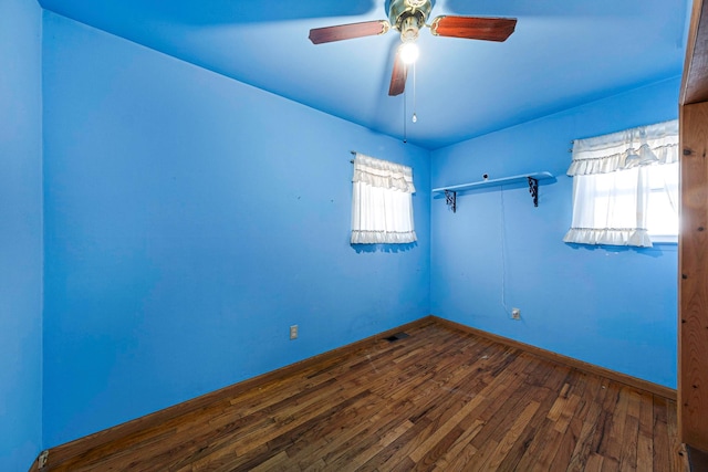 empty room with dark wood-type flooring and ceiling fan