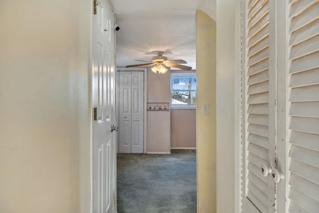 hall with dark colored carpet