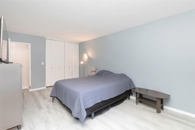 bedroom with a closet and light hardwood / wood-style flooring