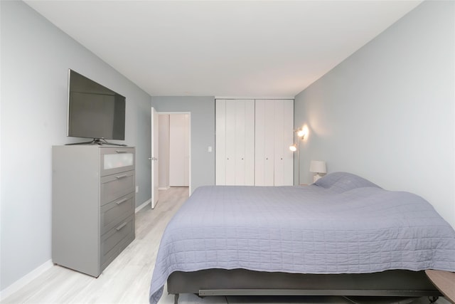 bedroom with light wood-type flooring and a closet