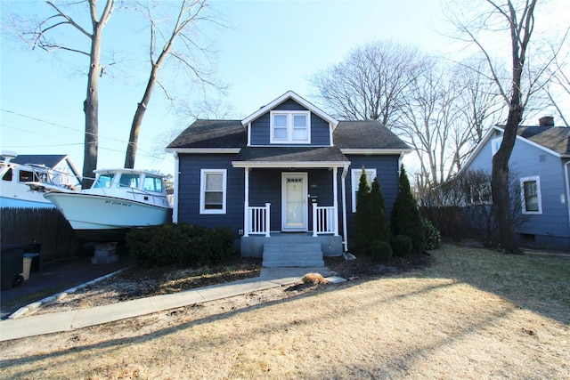 bungalow-style house with a shingled roof and covered porch