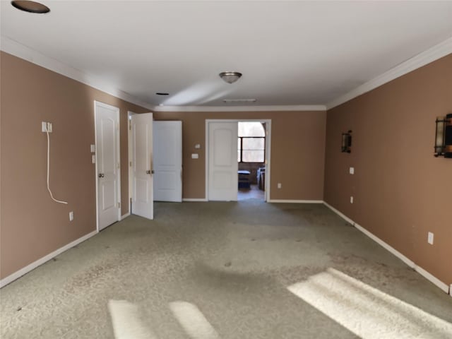 spare room featuring crown molding and carpet