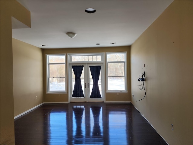 spare room featuring dark hardwood / wood-style floors and french doors