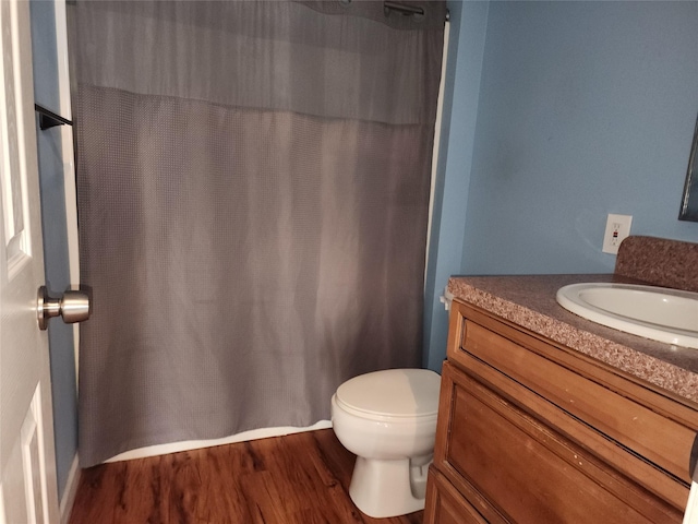 bathroom with wood-type flooring, vanity, and toilet