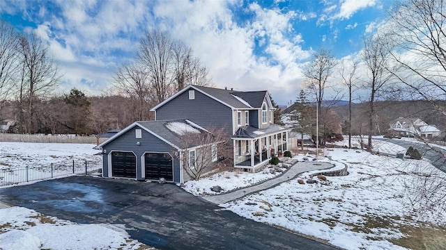 snow covered property with a garage