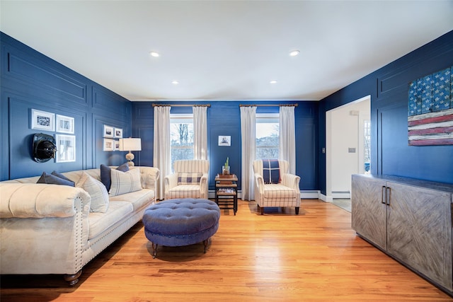 living room featuring a baseboard heating unit and light hardwood / wood-style floors