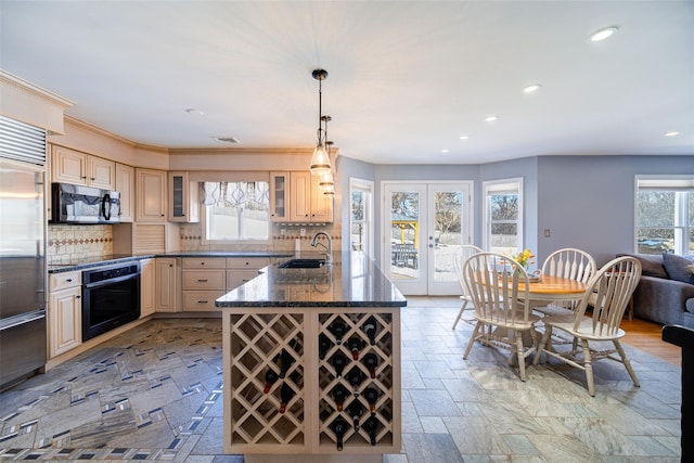 kitchen featuring sink, dark stone countertops, hanging light fixtures, stainless steel appliances, and french doors