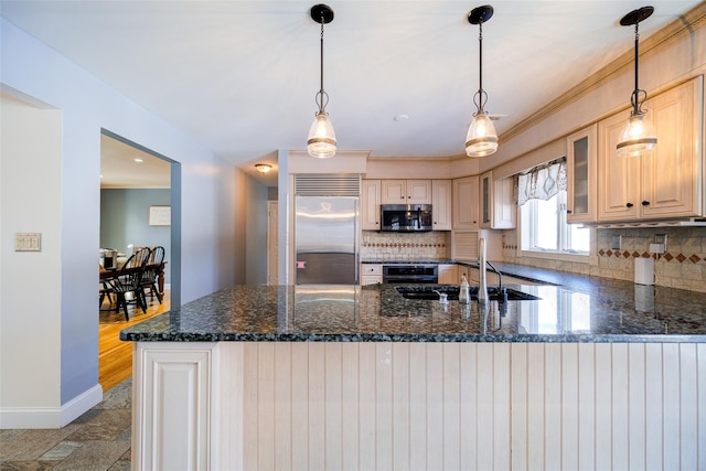 kitchen featuring sink, appliances with stainless steel finishes, tasteful backsplash, decorative light fixtures, and kitchen peninsula