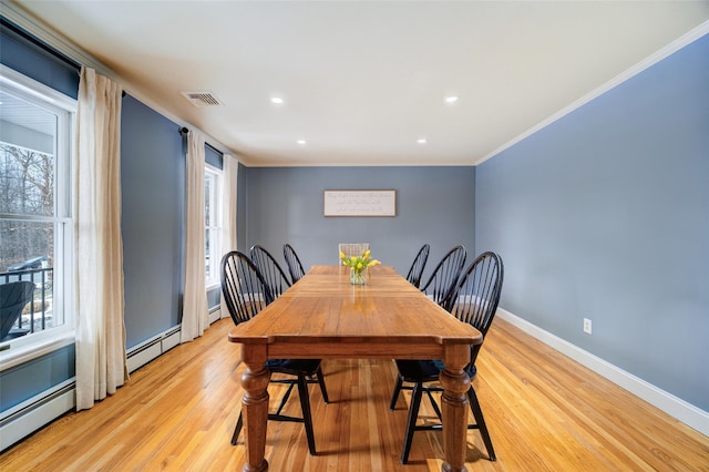 dining room with plenty of natural light, baseboard heating, and light hardwood / wood-style flooring