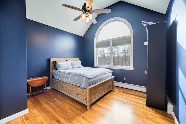 bedroom with lofted ceiling, a baseboard heating unit, light hardwood / wood-style flooring, and ceiling fan