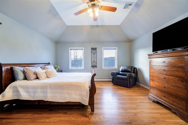 bedroom featuring ceiling fan, a baseboard heating unit, vaulted ceiling, and light wood-type flooring