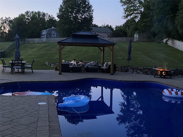 view of swimming pool with a gazebo, a yard, a patio area, and an outdoor living space with a fire pit