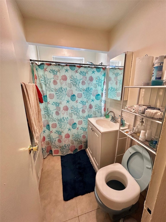 bathroom featuring vanity, toilet, tile patterned flooring, and decorative backsplash