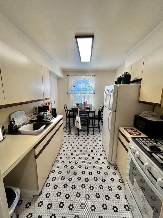 kitchen with sink, white gas stove, and light tile patterned floors