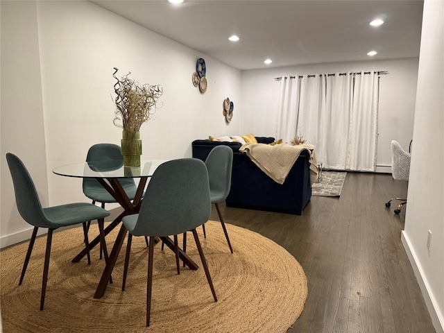 dining space with dark hardwood / wood-style floors and baseboard heating