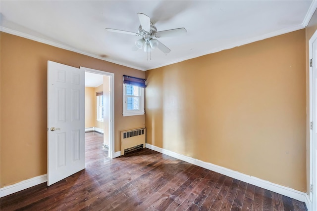 empty room with dark hardwood / wood-style flooring, radiator, ornamental molding, and ceiling fan