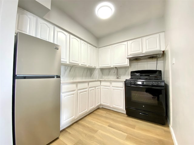 kitchen featuring light hardwood / wood-style flooring, stainless steel refrigerator, white cabinetry, tasteful backsplash, and gas stove